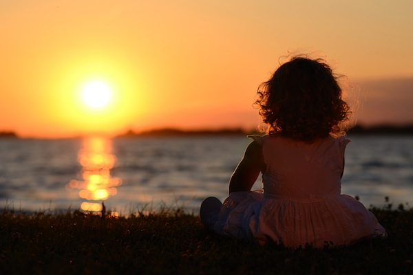 Relaxing young child in sunset